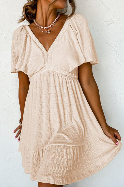 JO | Textured beige mini dress with deep V-neck for stylish women