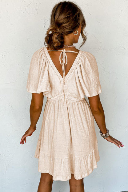 JO | Textured beige mini dress with deep V-neck for stylish women